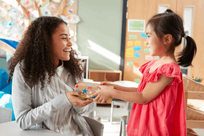 Une fille offre des chocolats artisanaux à son institutrice d'école